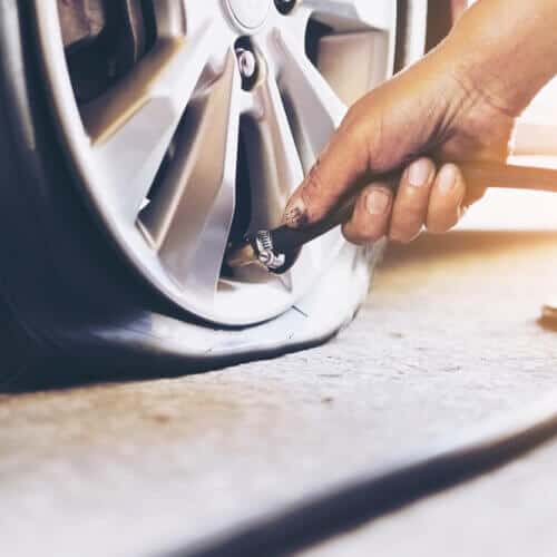 front view of hand filling a flat tire with air