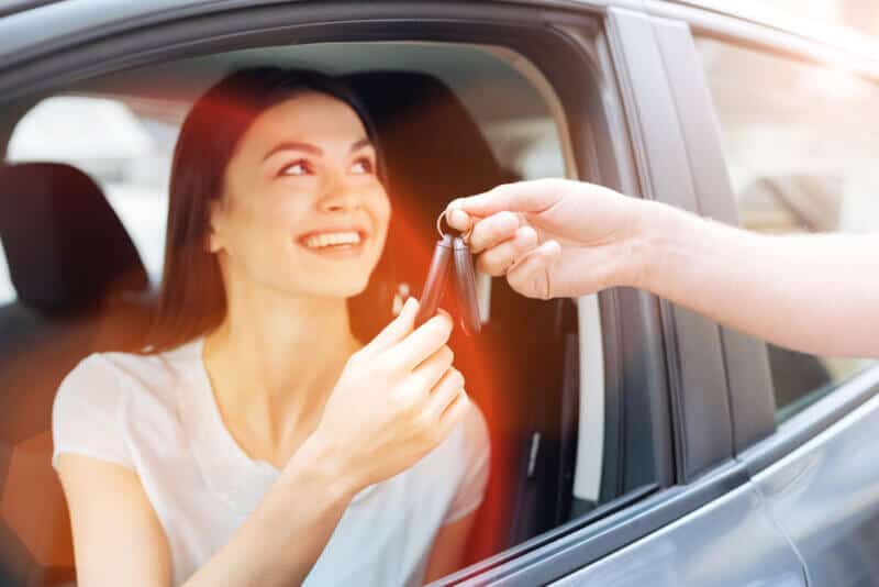 woman in car taking car keys from another person