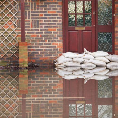 front view of front door of flooded house with sand bags
