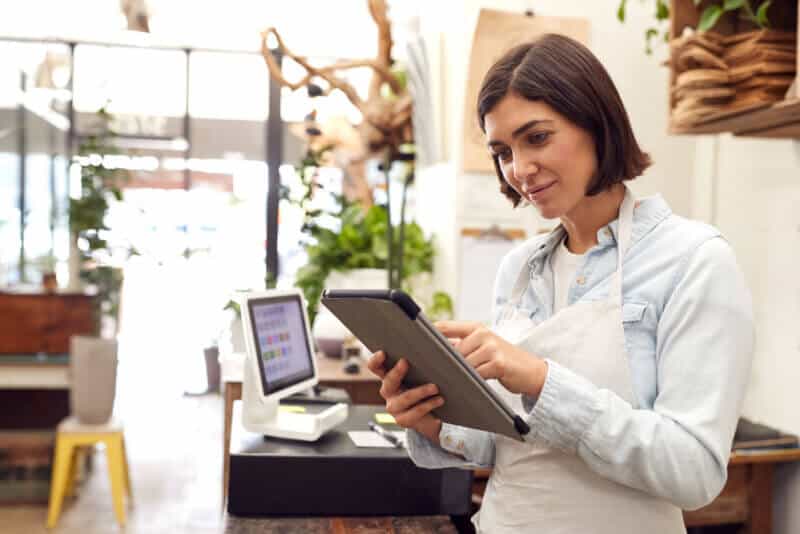 female business owner in shop looking at tablet