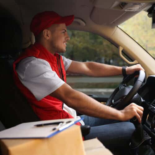 delivery man in commercial auto with boxes and insurance