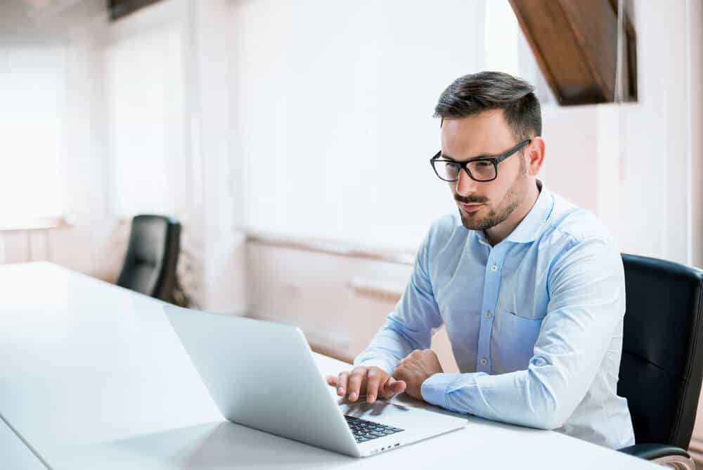 young man looking laptop for car insurance rates