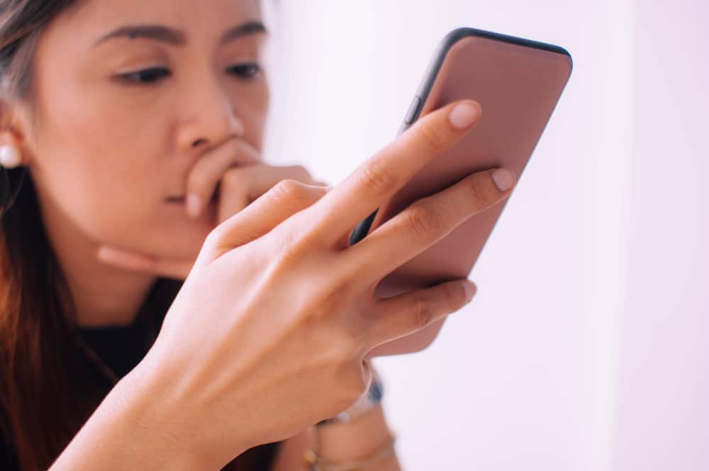 young woman is using a mobile phone to find earthquake insurance