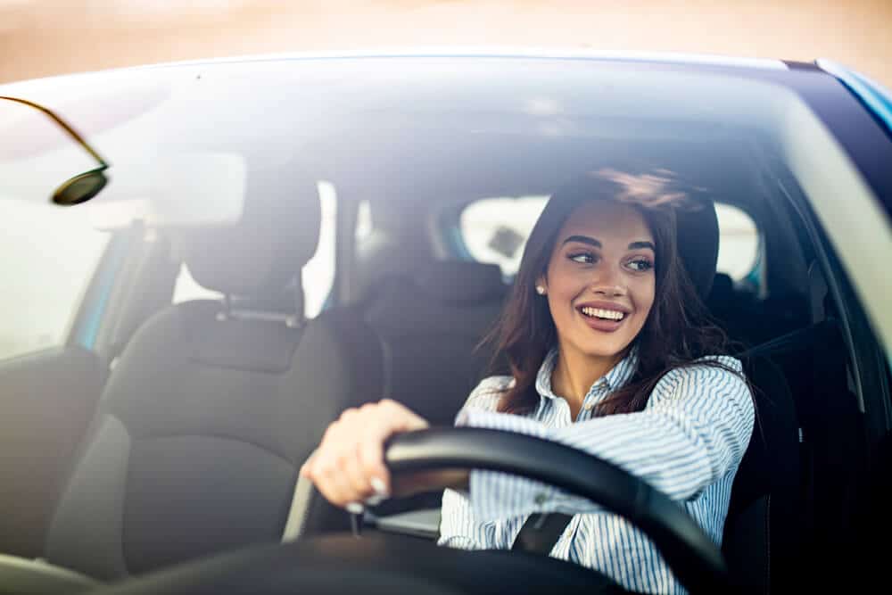 woman driving car smiling