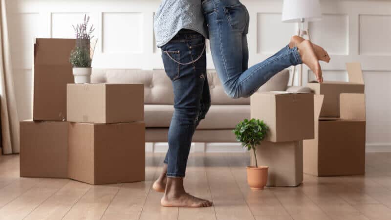 young couple standing in front of moving boxes