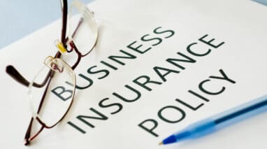 business insurance policy document with glasses