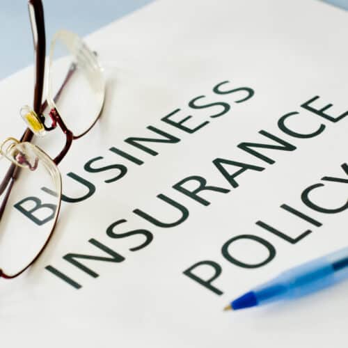 business insurance policy document with glasses