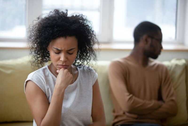 distressed couple sitting on couch