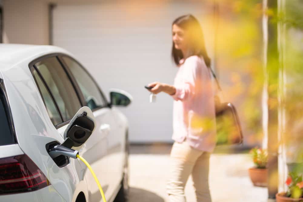 woman walking by electric car charging