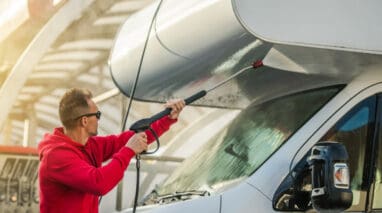 man washing exterior of rv