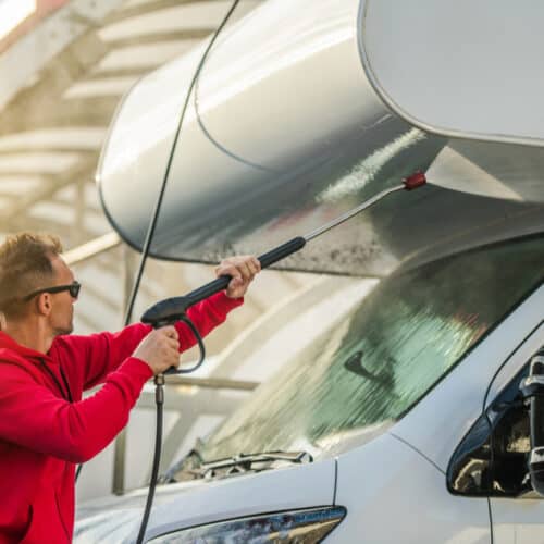 man washing exterior of rv