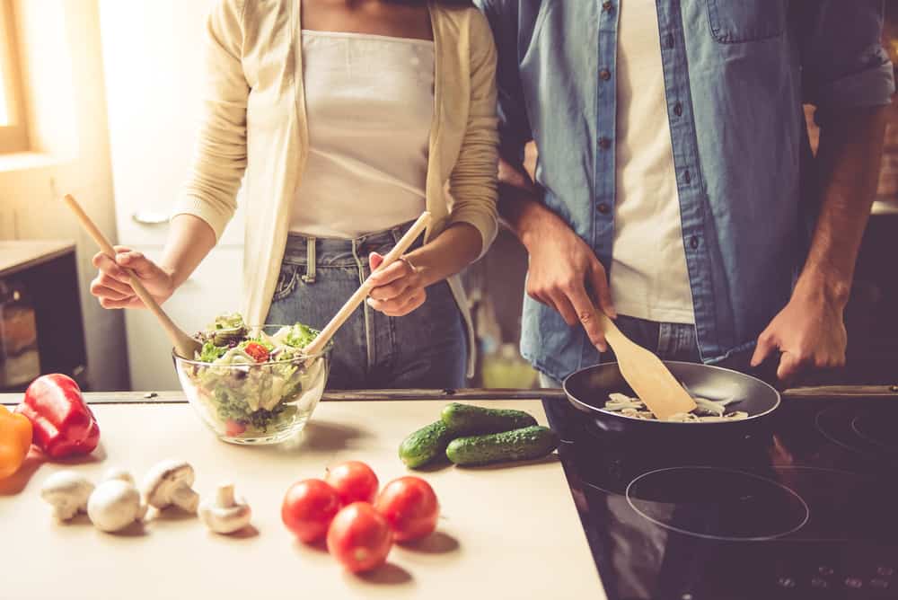 two people cooking in kitchen side by side