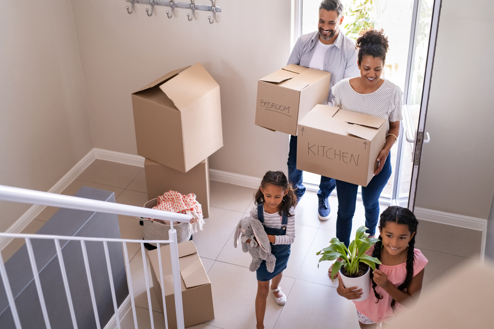 Multi-ethnic couple with 2 children moving into their new home