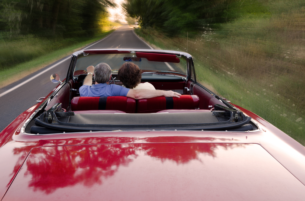 senior couple snuggles in their red car in washington