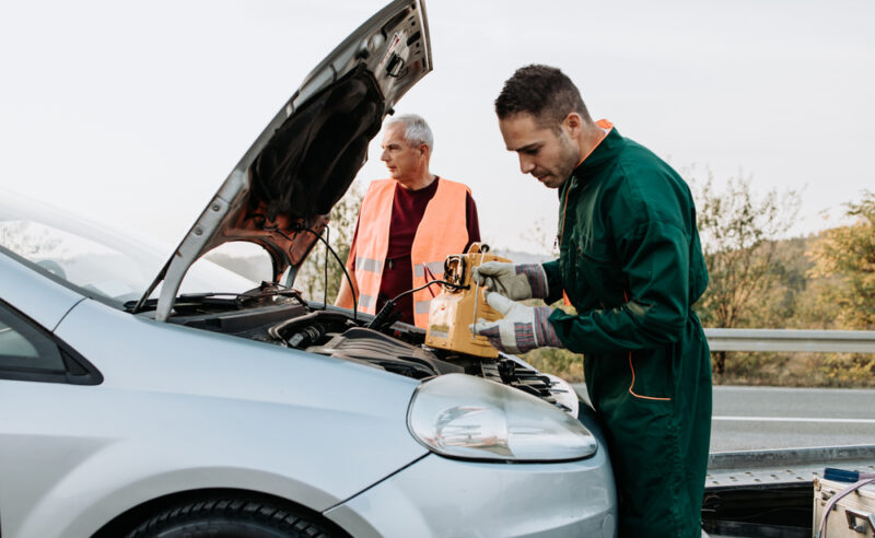 Roadside assistance technician checks battery