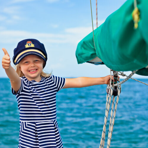 Little girl on a boat wearing the captain's hat - boat insurance in Washington