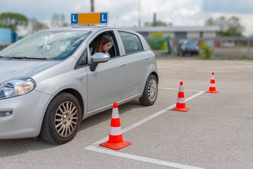 Girl taking defensive driving course looks out her window at cones on the road - cheap car insurance in Washington.