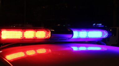 Red and blue flashing lights on top of a police car.