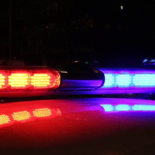 Red and blue flashing lights on top of a police car.