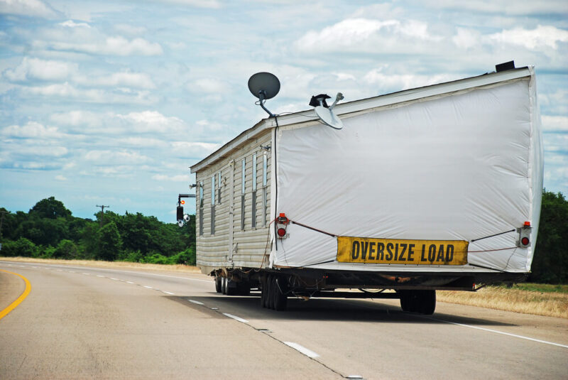 Modular home being transported along interstate highway - Affordable Washington Manufactured Home Insurance